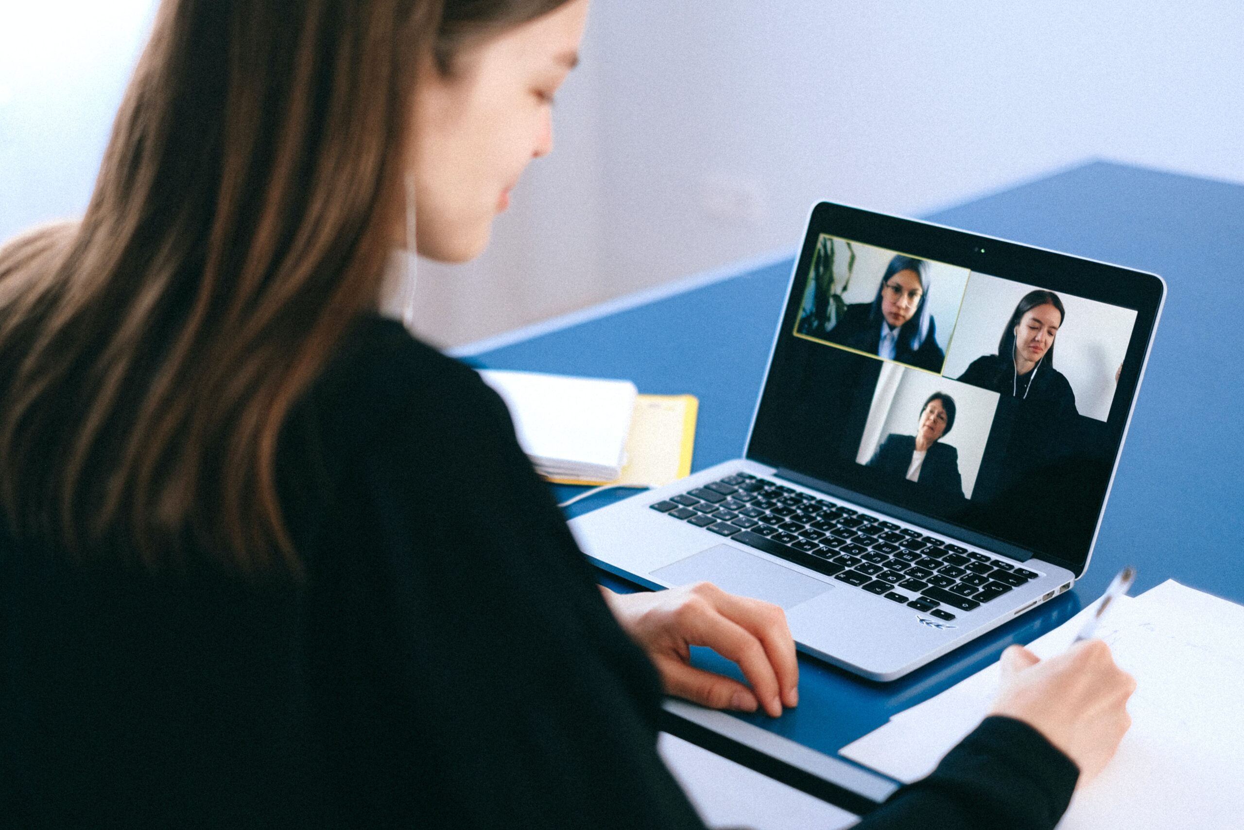 A person sitting in front of a laptop watching a webinar.